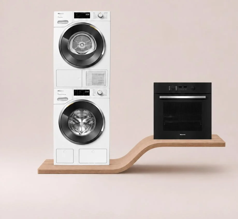 Colonna lavatrice e asciugatrice Miele accanto a un forno Miele